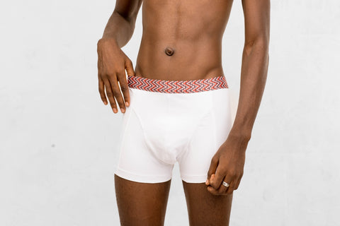 a man in white boxer briefs with a red and white belt around his waist
