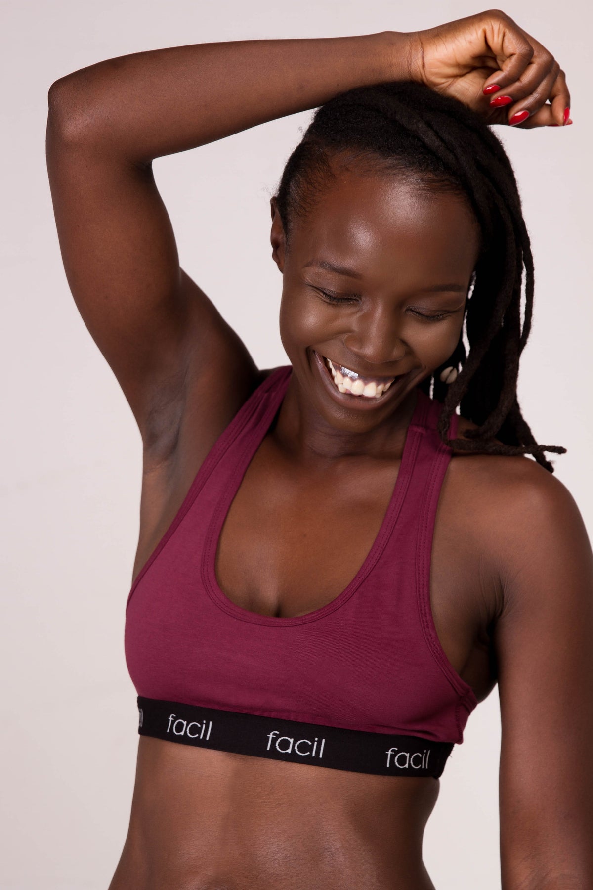 a woman in a burgundy bralette smiling