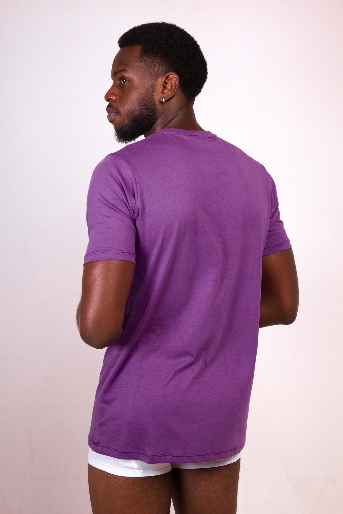 a man in a purple shirt and white underwear