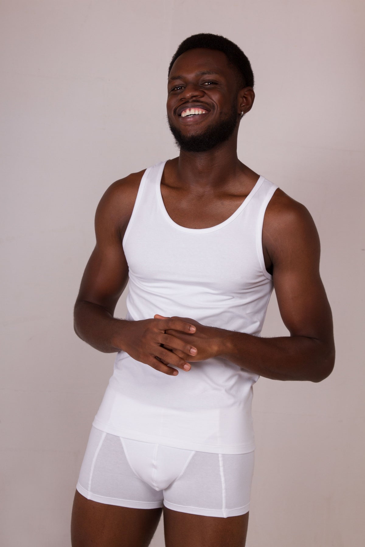 a man wearing a white tank top and white underwear