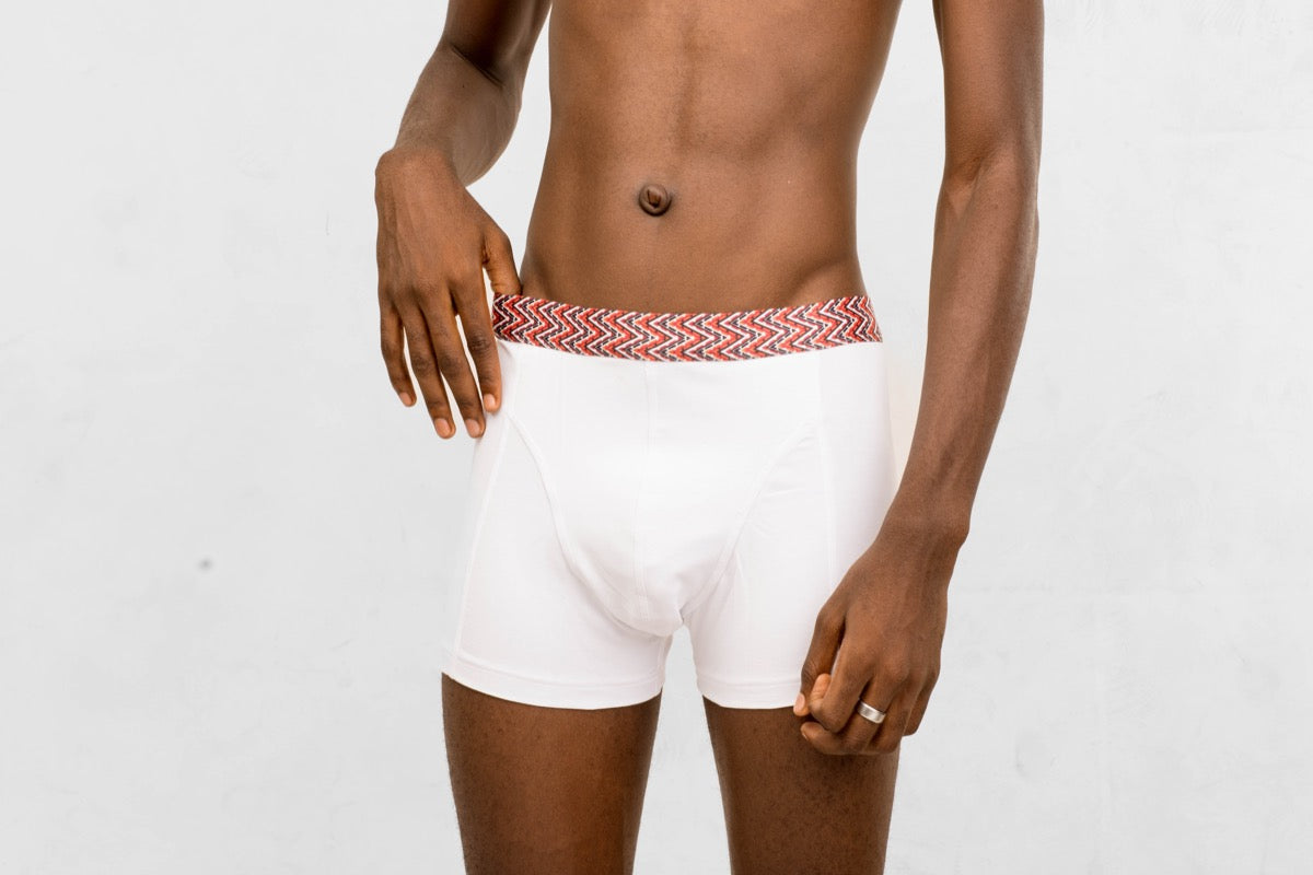 a man in white boxer briefs with a red and white belt around his waist