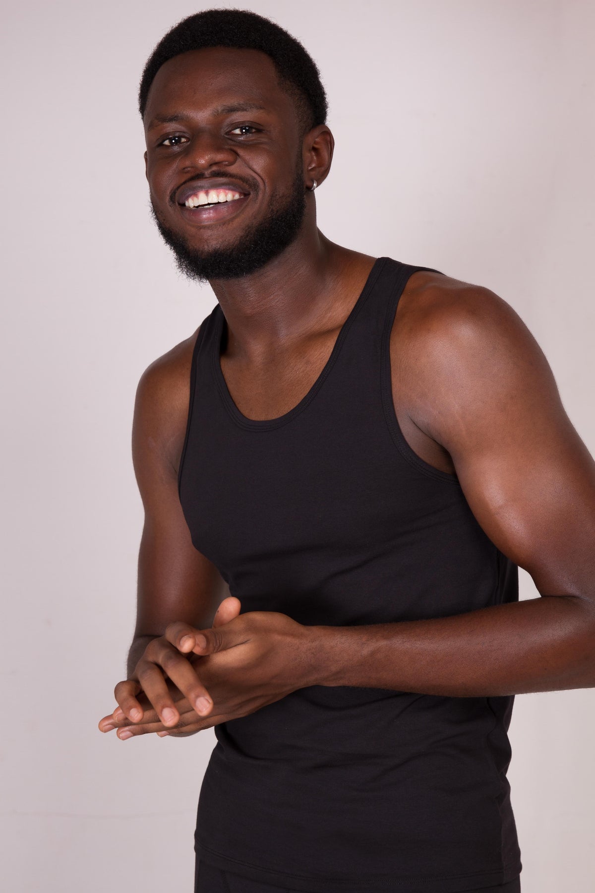 a man in a black tank top is smiling