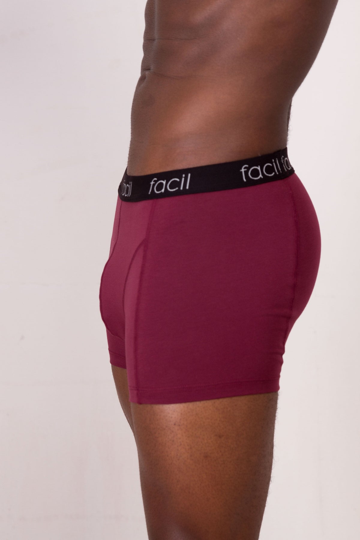 a man wearing a red boxer briefs with a black elastic waistband
