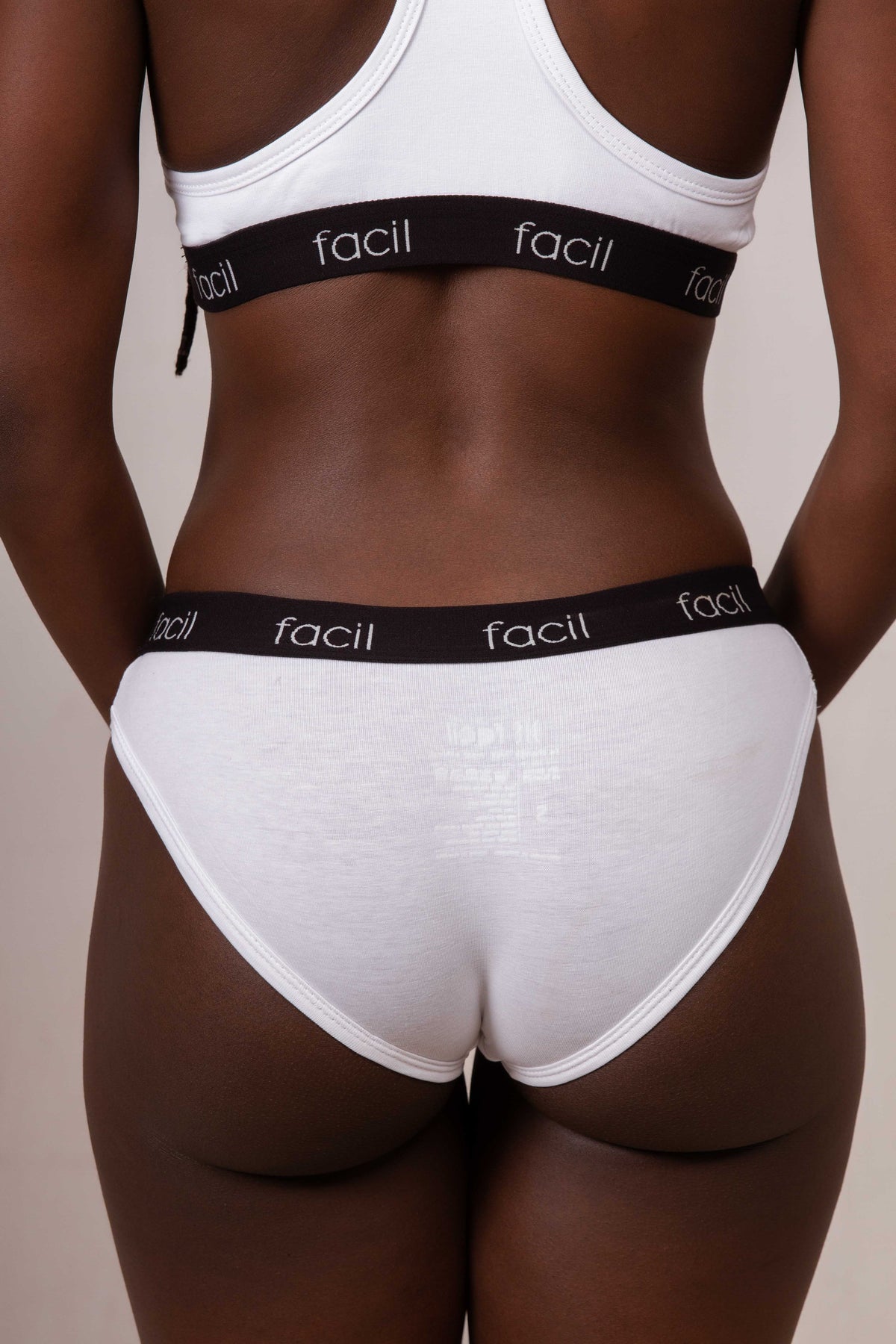 a woman wearing a white underwear with facil branded waistband